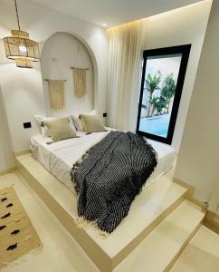 a bedroom with a bed with a black and white blanket at Dar Oliva Maison de luxe in Houmt Souk