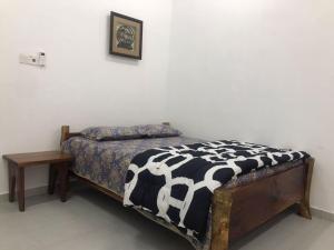 Laman Norras Homestay في Kepala Batas: غرفة نوم بسرير وبطانية بيضاء وسوداء