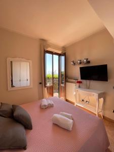 een slaapkamer met een groot bed en handdoeken bij Sunset house in Rosignano Marittimo