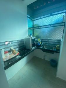 cocina con fregadero y microondas en Laman Norras Homestay en Kepala Batas