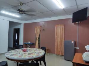 Kepala BatasにあるLaman Norras Homestayのテーブルとテレビが備わる部屋