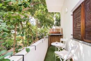 uma varanda com mesa, cadeiras e árvores em Beautiful 2Bd w/ Private Balcony by Sea N' Rent em Tel Aviv