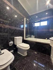 een badkamer met een toilet, een wastafel en een bad bij Casa Travessa do Monte by LovelyStay in Celorico de Basto