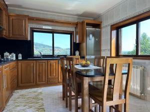 cocina con mesa, sillas y ventanas en Casa Travessa do Monte by LovelyStay, en Celorico de Basto