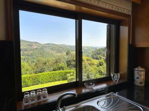 uma janela de cozinha com um lavatório e vista para as montanhas em Casa Travessa do Monte by LovelyStay em Celorico de Basto