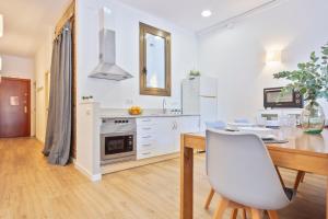 a white kitchen with a table and a dining room at Citytrip Barceloneta Beach in Barcelona