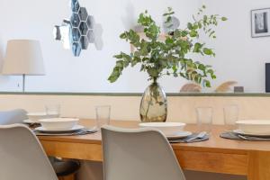 a dining room table with a vase with a plant at Citytrip Barceloneta Beach in Barcelona