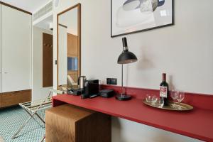 a red counter with wine glasses and a lamp at GWARNA Aparthotel City Center Wrocław by Renters in Wrocław
