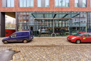 two cars parked in front of a building at GWARNA Aparthotel City Center Wrocław by Renters in Wrocław