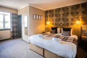 Traquair Arms Hotel في إيتنيرليثيم: غرفة نوم بسرير كبير في غرفة