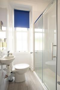 a white bathroom with a toilet and a shower at Traquair Arms Hotel in Innerleithen +66 photos