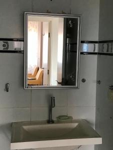 uma casa de banho com um lavatório e um espelho em Aconchegante, ótima localização e vista para o mar no Recife