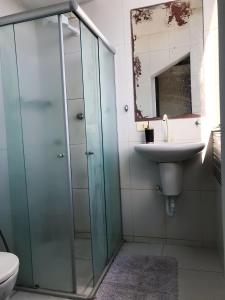 uma casa de banho com uma cabina de duche em vidro e um lavatório. em Aconchegante, ótima localização e vista para o mar no Recife