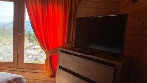a flat screen tv in a bedroom with a window at BioFarm Gramsh in Kodovjat