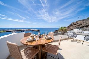 una mesa de madera en un patio con vistas al océano en Casa Galana, en Tías