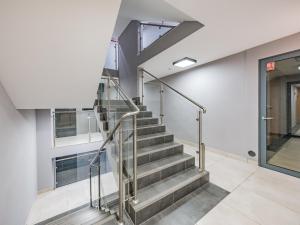 - un escalier dans un bâtiment avec une porte en verre dans l'établissement Hello Apartments Classy Industrial Browar Gdansk, à Gdańsk