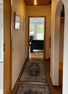 un pasillo con una puerta que conduce a una sala de estar en Aalhues-Ferienwohnung-ueber-2-Etagen-fuer-4-Erwachsene-und-1-Kind en Westerland