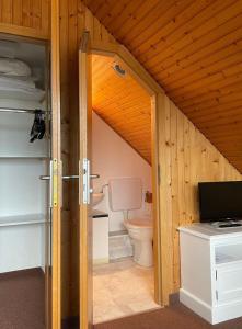 una puerta abierta a un baño con aseo en Aalhues-Ferienwohnung-ueber-2-Etagen-fuer-4-Erwachsene-und-1-Kind en Westerland