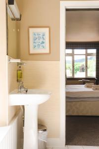 Traquair Arms Hotel في إيتنيرليثيم: حمام مع حوض وسرير