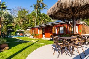 a table and chairs with an umbrella and a resort at Pousada Mar de Dentro in Florianópolis