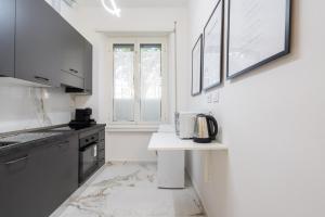 a kitchen with white walls and a table with a microwave at [8 Minutes from the Centre] A/C -Wi-Fi and Netflix in Rome