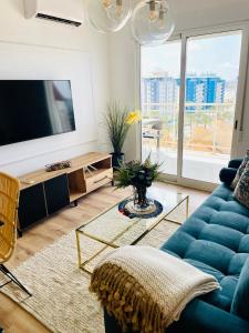 sala de estar con sofá azul y TV en Carla II View Apartment, en La Manga del Mar Menor