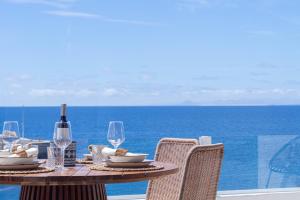 a table with a bottle of wine and glasses on the ocean at Casa Galana in Tías