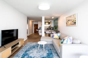 a living room with a couch and a tv at Bayview 208 in Hermanus