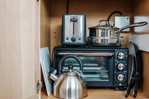 a tea kettle sitting on top of a toaster oven at Downtown Tiny Home near Shenandoah National Park in New Market
