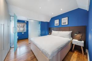 a bedroom with blue walls and a large bed at Beautiful One Bedroom Apartment in Soho in London