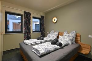 a bedroom with two beds and two windows at Domaine Edegger - Organic Winery Badacsony in Badacsonytomaj