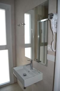 uma casa de banho com um lavatório branco e um espelho. em Hotel Oasis em Conil de la Frontera