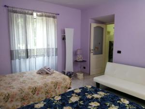 een slaapkamer met 2 bedden, een bank en een raam bij B & EAT IL BORGO in Segno