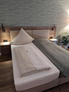 a bed with white sheets and pillows on it at PaGa - Parkgaststaette in Ehrenburg