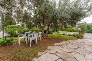 a table and chairs sitting under a tree at Domina in Pula
