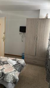 - une chambre avec un lit et une armoire en bois dans l'établissement pensión La Parada, à Alicante