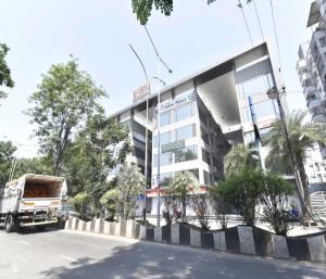 un camión está estacionado frente a un edificio en Hotel Infini Palace City Center, en Surat