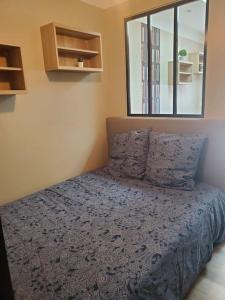 una camera da letto con un letto con un piumone blu e una finestra di Chaillot 1 a Saintes
