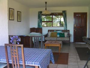 a living room with a table and a couch at Tsitsikamma on Sea Self-catering Cottages in Witelsbos