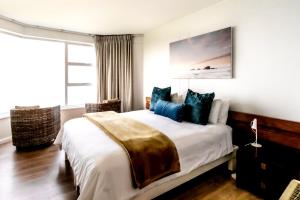 sypialnia z dużym łóżkiem z niebieskimi poduszkami w obiekcie Bayview 208 w mieście Hermanus