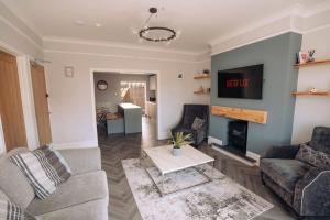 a living room with a couch and a tv at The Dunes, Lytham St Annes in Lytham St Annes
