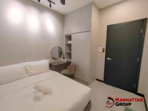 ein Schlafzimmer mit einem weißen Bett und einer schwarzen Tür in der Unterkunft Neu Suites By Manhattan Group in Kuala Lumpur