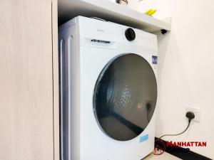 eine weiße Waschmaschine mit offener Tür in der Unterkunft Neu Suites By Manhattan Group in Kuala Lumpur