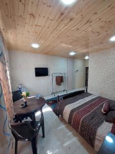 a bedroom with a bed and a table and a tv at Green Garden Rooftop in Madaba