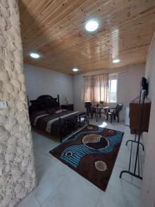 a bedroom with a bed with a rug on the floor at Green Garden Rooftop in Madaba