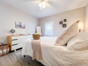 1 dormitorio blanco con 1 cama y vestidor en Charming historic Wilmington vacation bungalow., en Wilmington