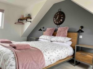 a bedroom with a bed with a clock on the wall at The Sails in East Wittering