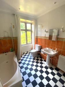 a bathroom with a sink and a tub and a toilet at Thornhaugh Old Rectory in Peterborough