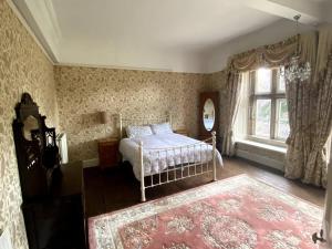 a bedroom with a bed and a large window at Thornhaugh Old Rectory in Peterborough