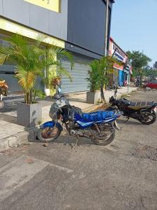two motorcycles parked in a parking lot in front of a building at Hotel Palms Residency, Chembur Mumbai in Mumbai